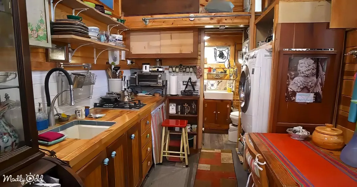 A cozy, compact kitchen with wooden cabinets, a sink, stove, and various kitchen items.