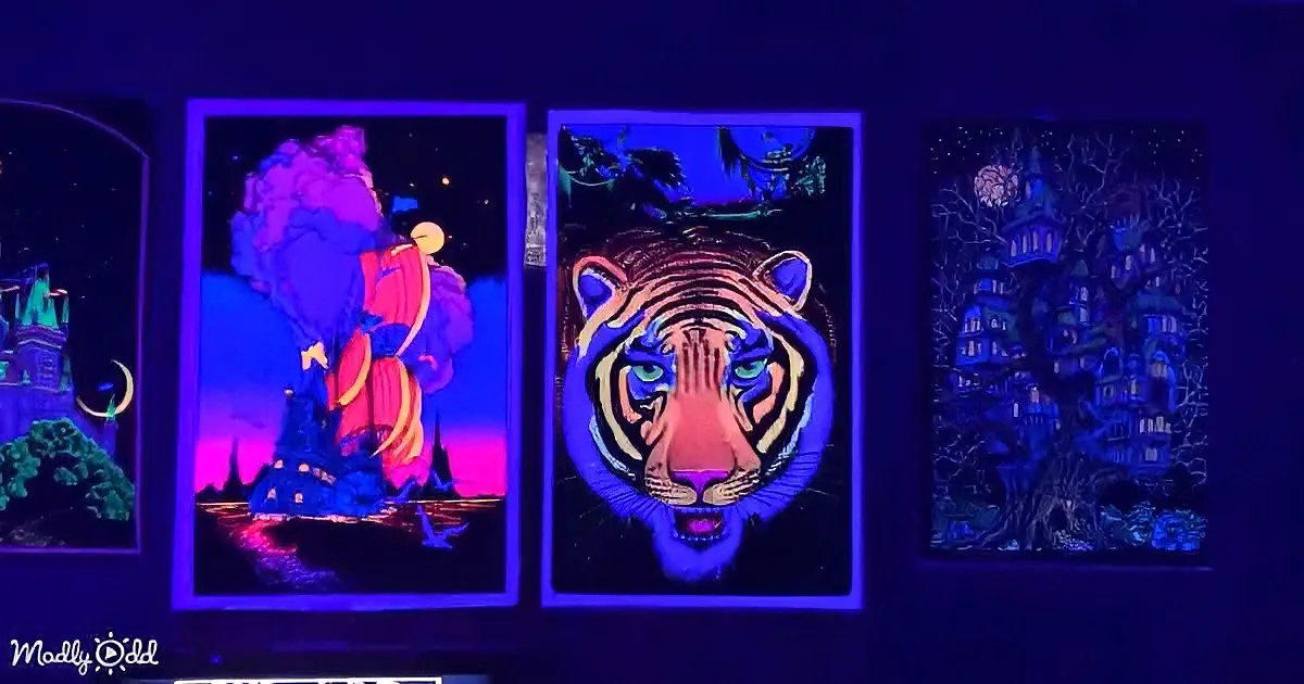 A glowing tiger face is the centerpiece of a triptych of UV-reactive artwork.