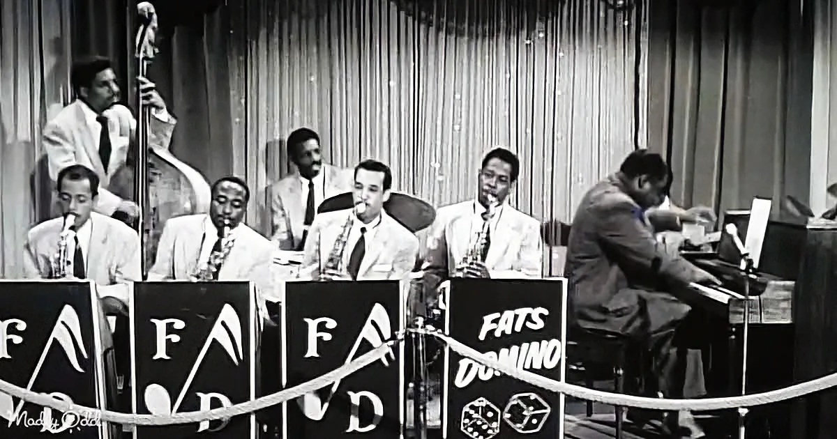 Fats Domino's band performs on stage with musicians playing instruments.