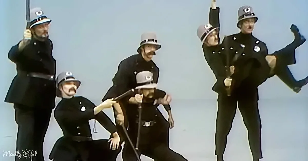 A group of police officers in uniform are performing a synchronized dance routine.