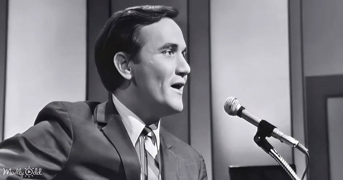 A man in a suit sings into a microphone, his eyes closed, in a black-and-white setting.