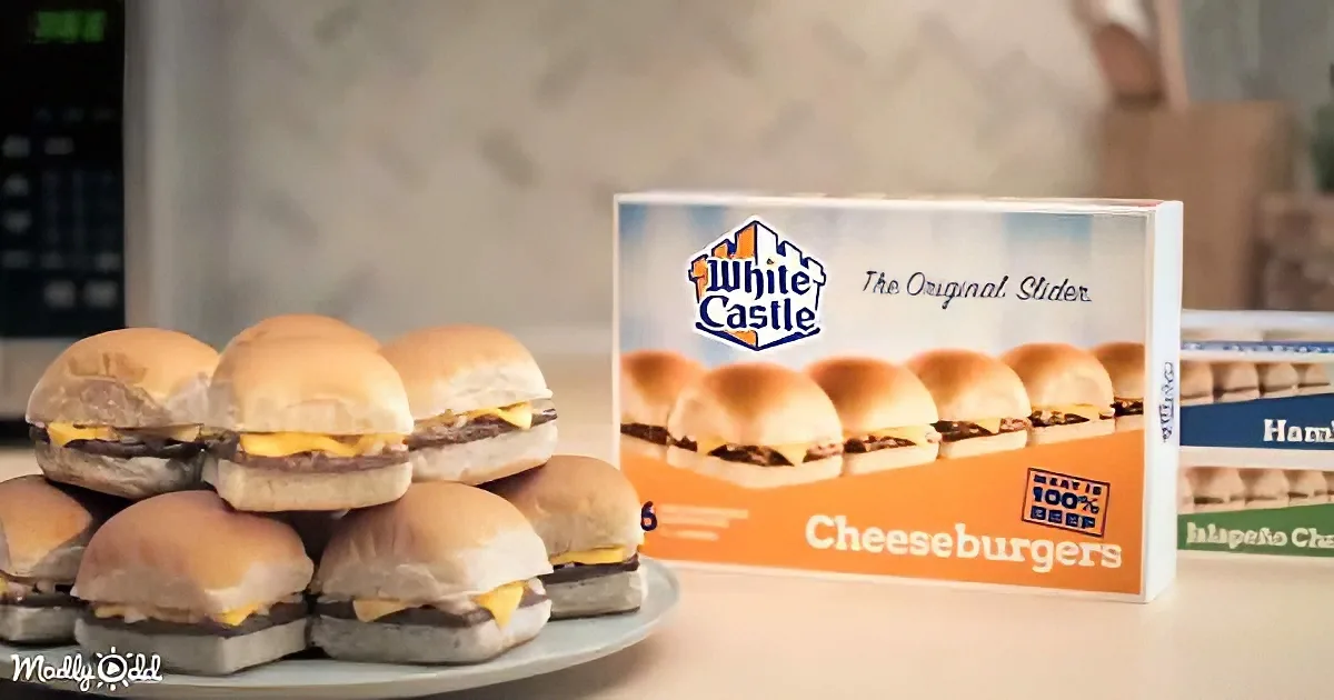 A plate of mini cheeseburgers sits next to a White Castle cheeseburger box on a kitchen counter.
