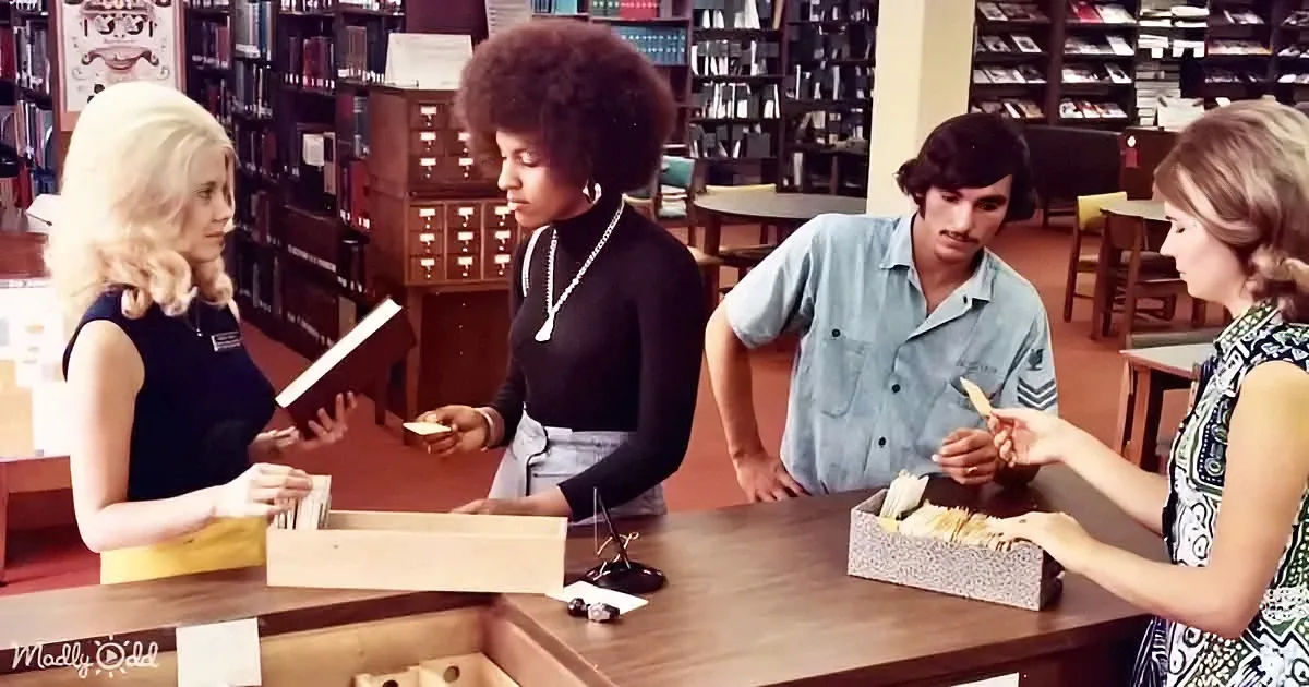 A woman with an afro assists patrons at a library counter, surrounded by books and filing cabinets.