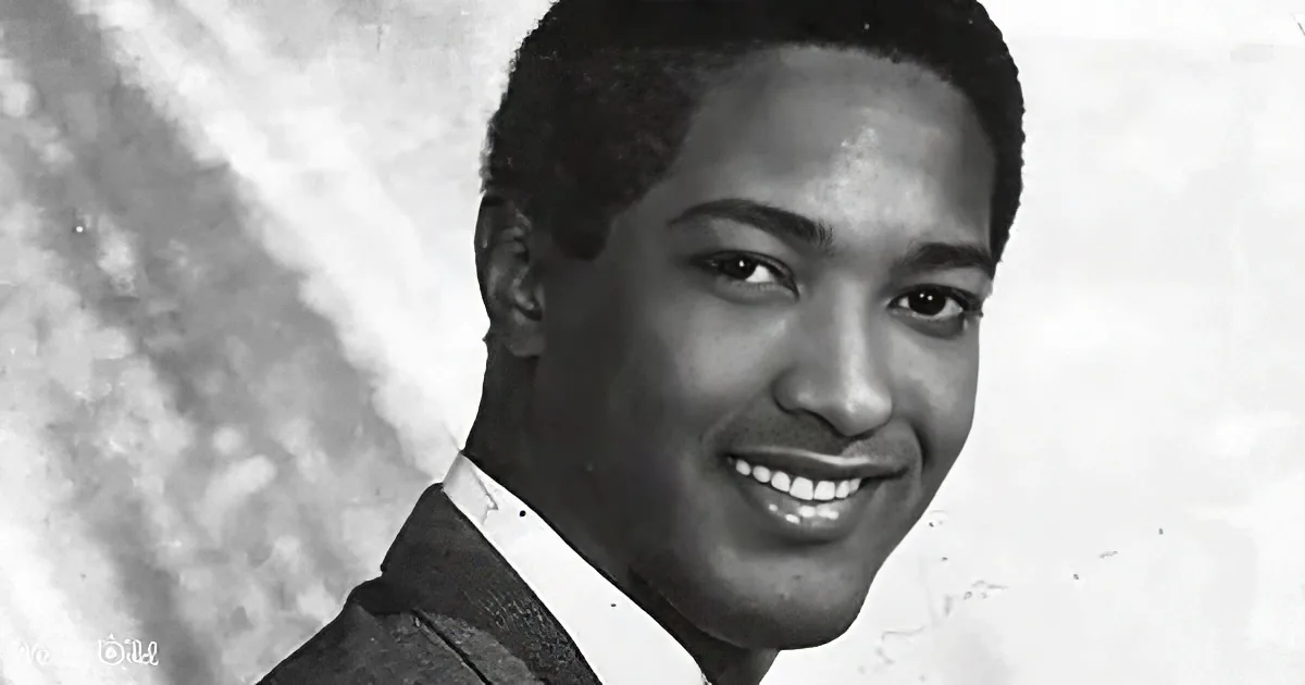 A smiling man in a suit and tie, looking directly at the camera.