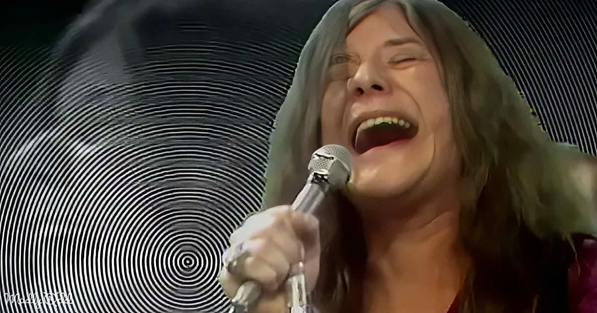 A person with long hair sings passionately into a microphone against a swirling background.