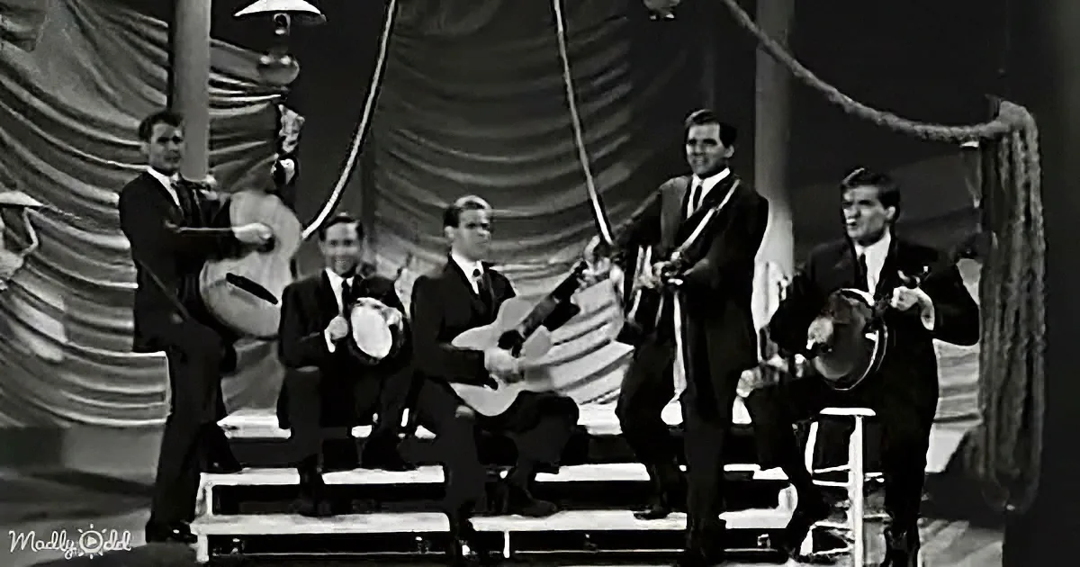 A group of musicians in suits perform on stage with various instruments.