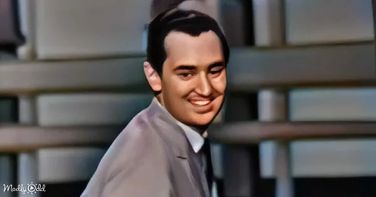 A man in a suit and tie smiles warmly, with a blurred background of steps.