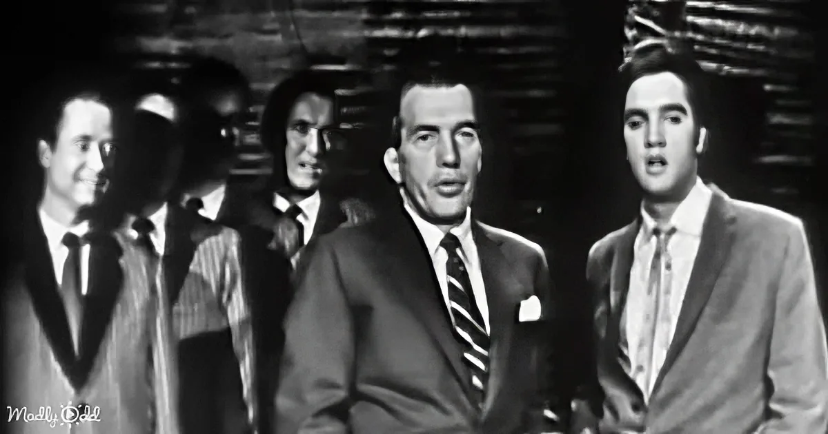 Elvis Presley sings alongside a group in formal attire, likely from a musical performance.