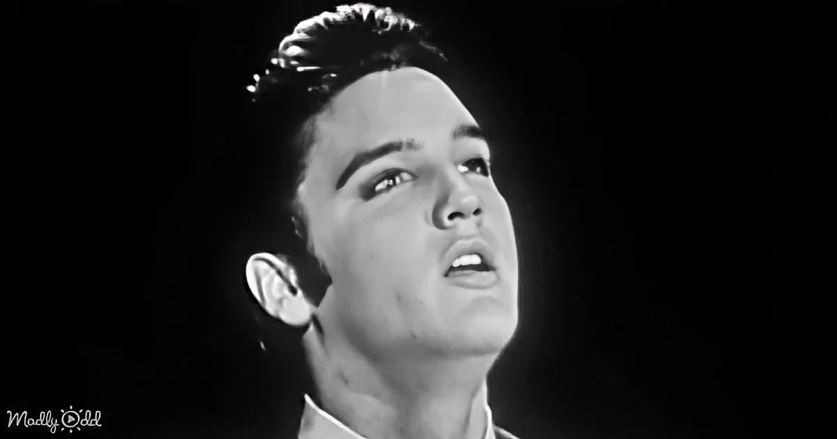 A man with a serious expression, looking upwards, in a black-and-white image.