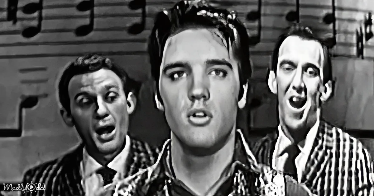 Elvis Presley sings passionately with two backup singers in a black-and-white musical scene.