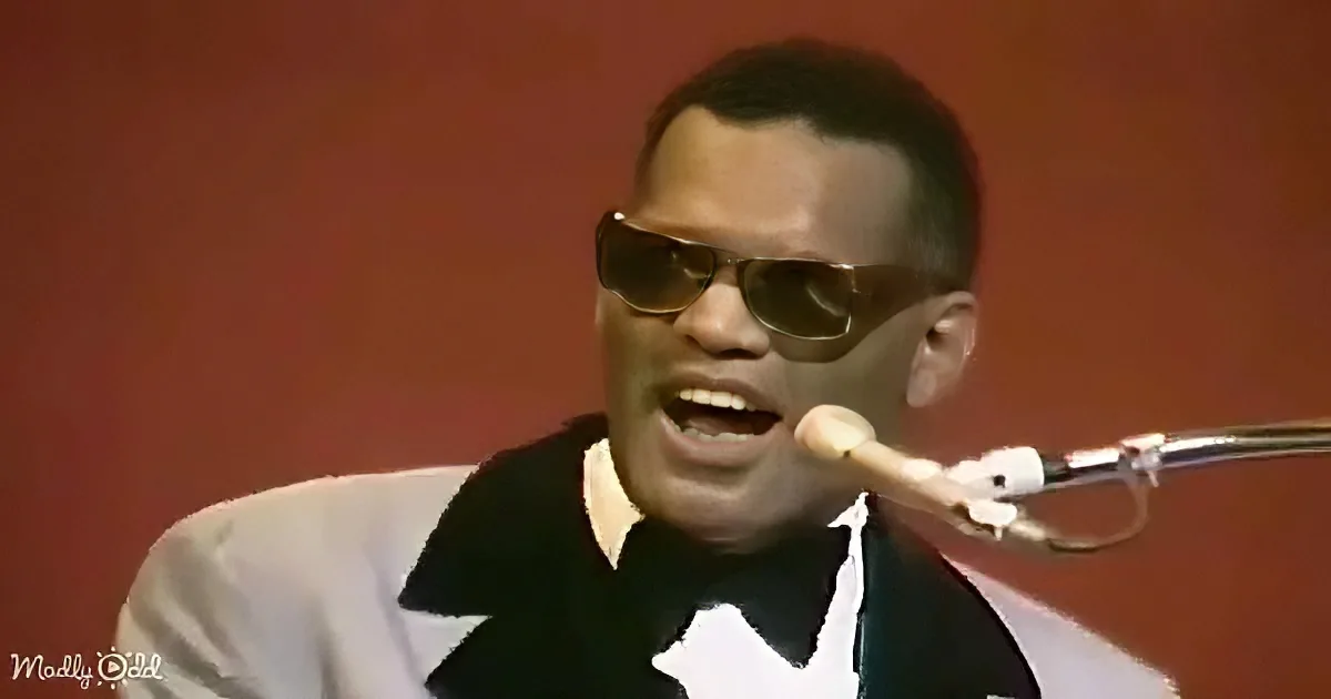 A man in sunglasses and a white shirt sings into a microphone against a red background.