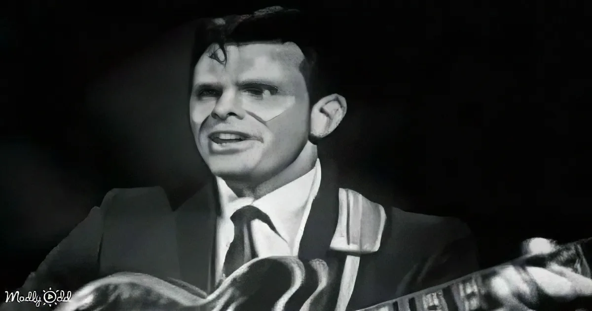 A man in a suit and tie is singing into a microphone, holding a guitar.