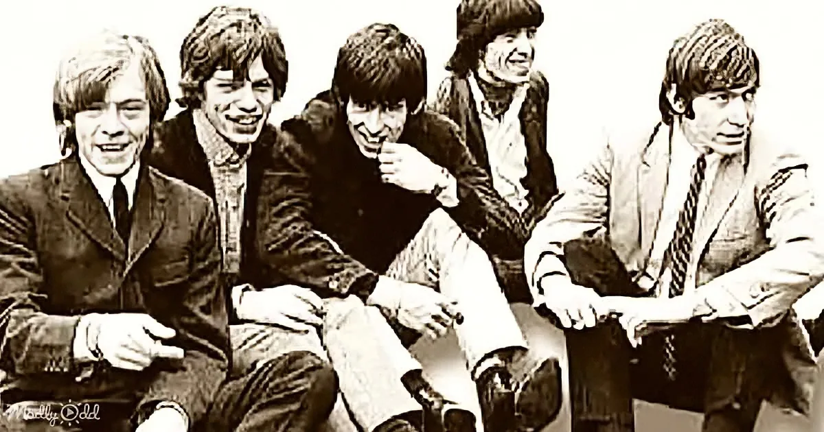 Five men in suits and casual attire are seated together, smiling and posing for a photo.