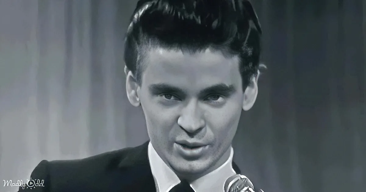 A man in a suit and tie, looking slightly downward, with a serious expression.