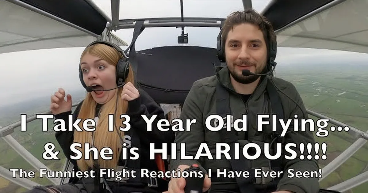 A person in a small aircraft with a surprised expression, wearing headphones and a harness.