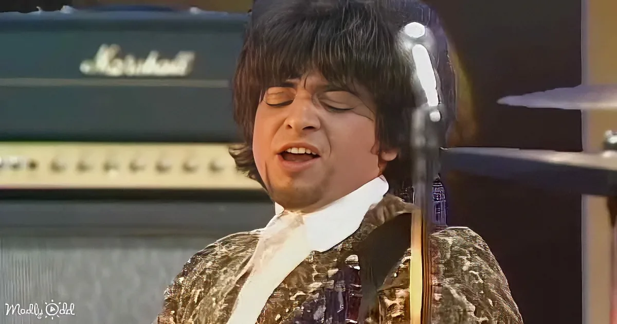 A man in a period costume sings passionately, with a Marshall amplifier in the background.