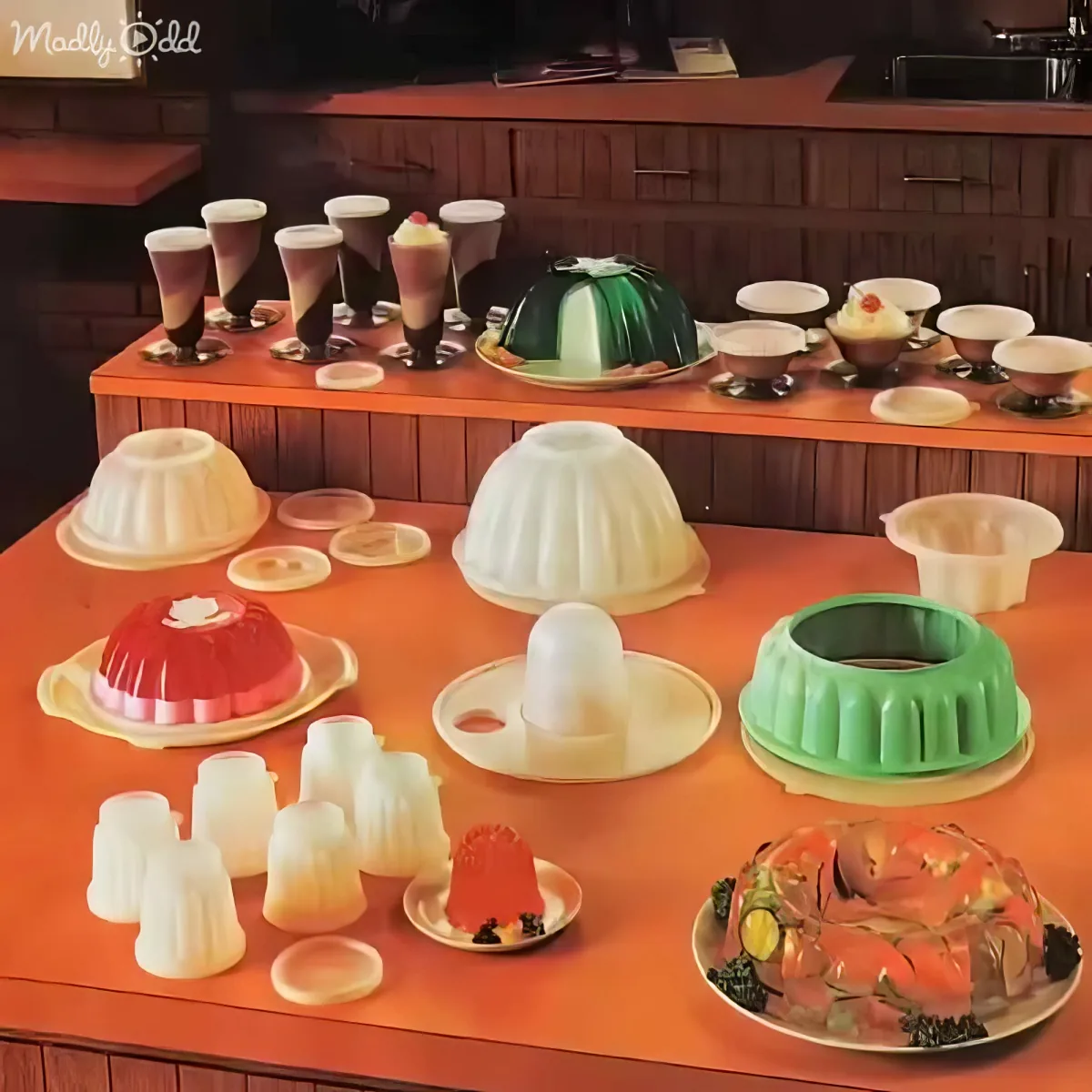 A vibrant display of colorful jello molds and desserts on a wooden counter.
