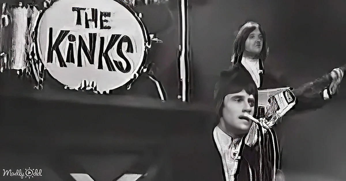 The Kinks band members perform on stage, with a drummer and guitarist in focus.