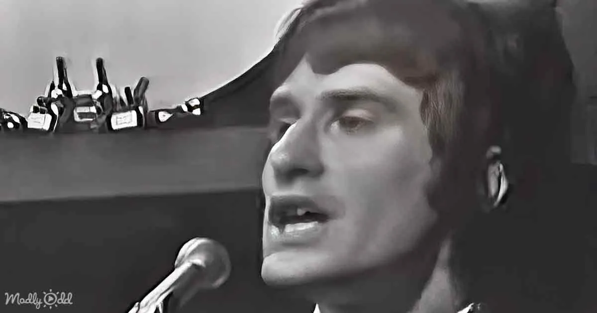 A person singing into a microphone, wearing headphones, with a black-and-white filter.
