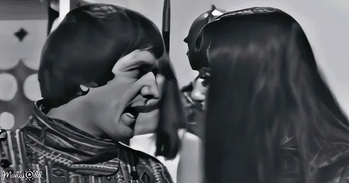 Batman and a woman in a costume are facing each other, with Batman appearing to be in a confrontational stance.