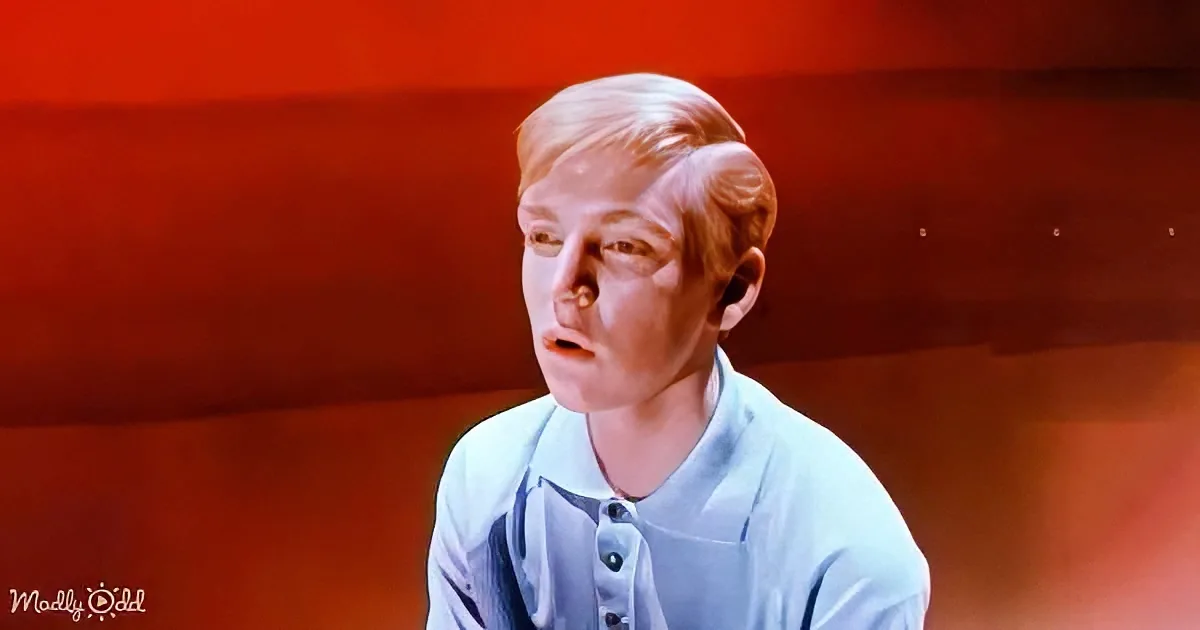 A person in a light blue shirt appears surprised or shocked, with a red-tinted background.