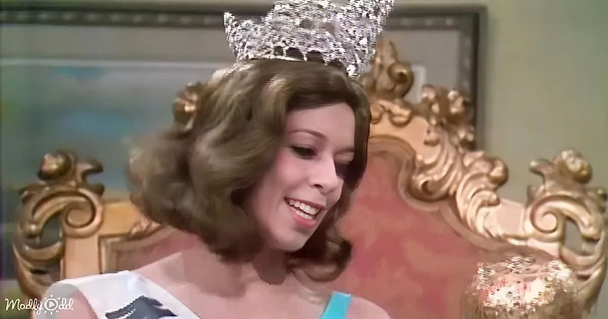 A woman in a tiara and white dress smiles, seated on an ornate gold throne.