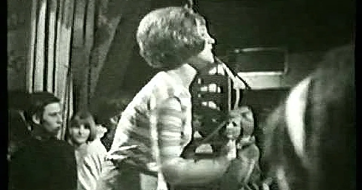 A smiling woman with short hair, wearing a white shirt, in a black and white photo.