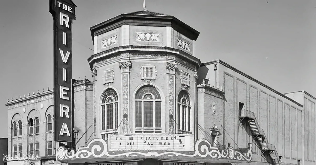The Riviera theater, a historic venue with ornate architecture and a prominent marquee, stands tall against a clear sky.