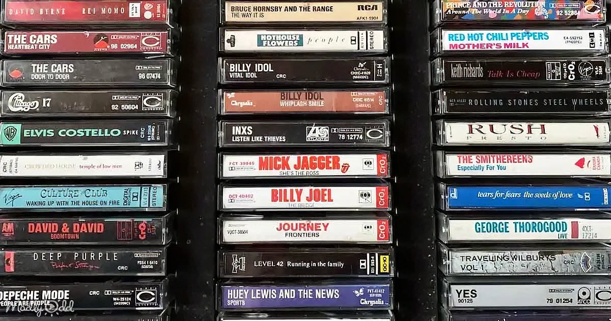 A collection of cassette tapes featuring various artists like The Cars, Billy Idol, and Journey.