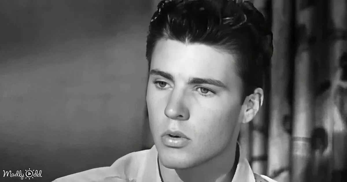 A man with dark, styled hair and a light-colored shirt is shown in a close-up, looking slightly to the side.