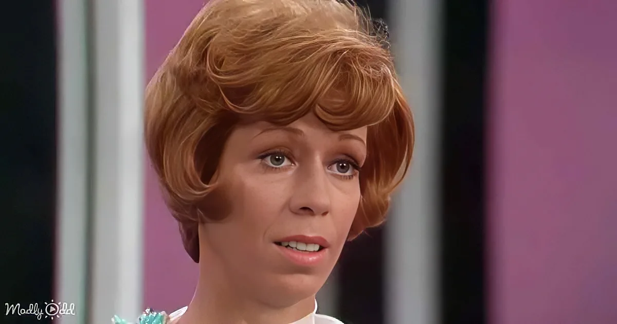 A person with short, styled red hair and a light blue top is shown against a pink and white striped background.