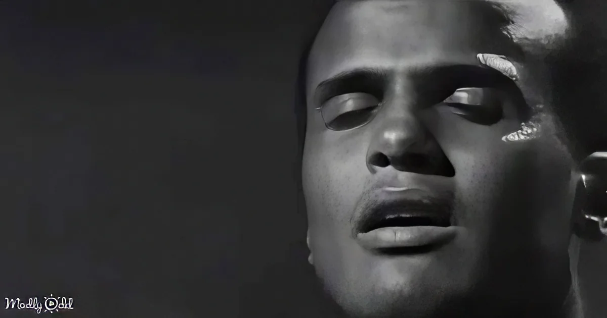 A close-up of a person with eyes closed, mouth slightly open, and a dark background.