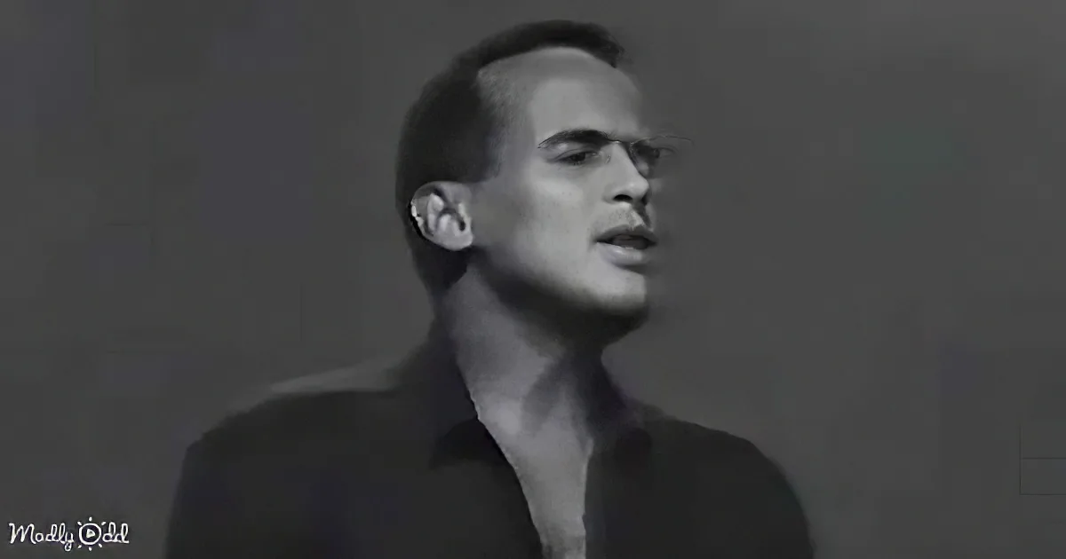 A man in a dark suit, head tilted back, mouth slightly open, in a grayscale image.