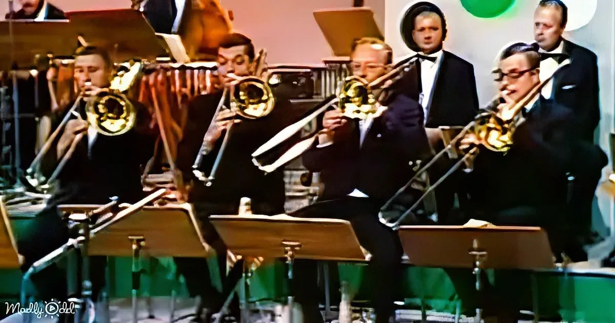 A group of musicians in formal attire plays brass instruments in a band setting.