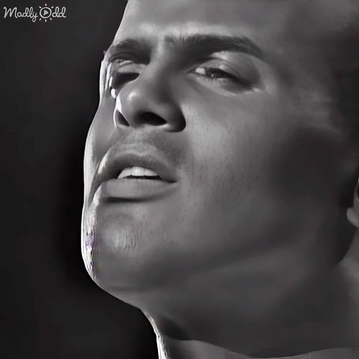 A close-up of a man's face, looking upward, with a black-and-white filter and a watermark in the corner.