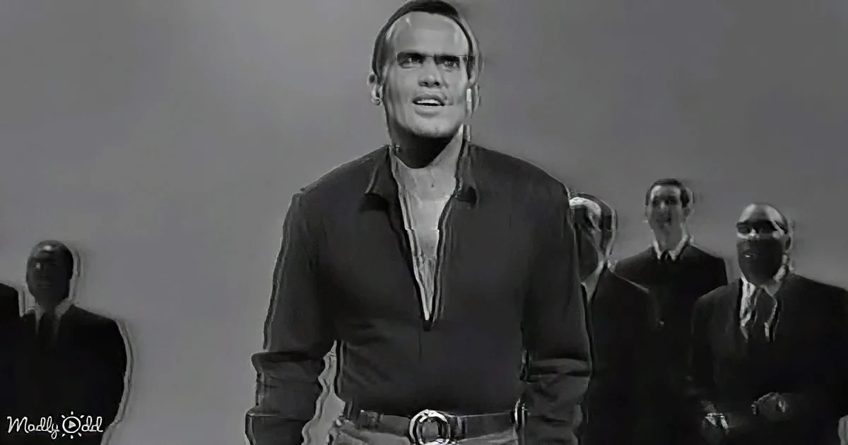 A man in a dark shirt and light pants stands in front of a group of similarly dressed figures.