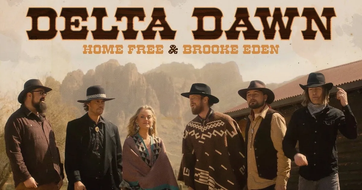 Six people in Western attire, including hats and ponchos, stand in front of a mountainous backdrop.