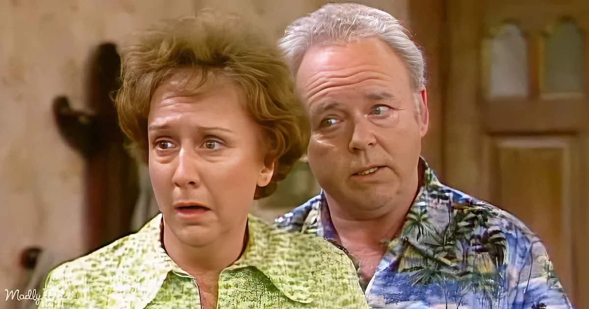 A woman in a green floral shirt looks surprised, standing next to a man in a tropical shirt.