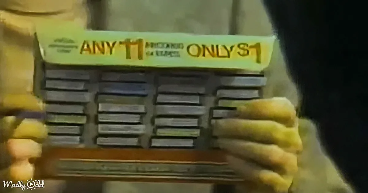A person in yellow gloves holds a vintage radio with a "ANY 11 ONLY $1" sign above it.