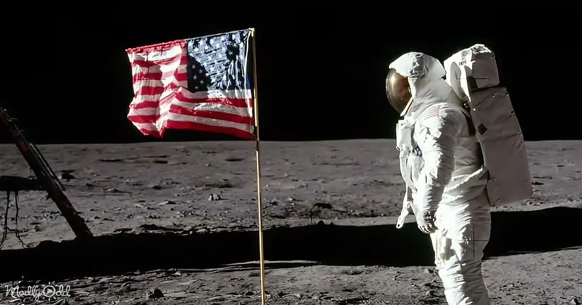 An astronaut stands on the moon next to the American flag, with a lunar module in the background.