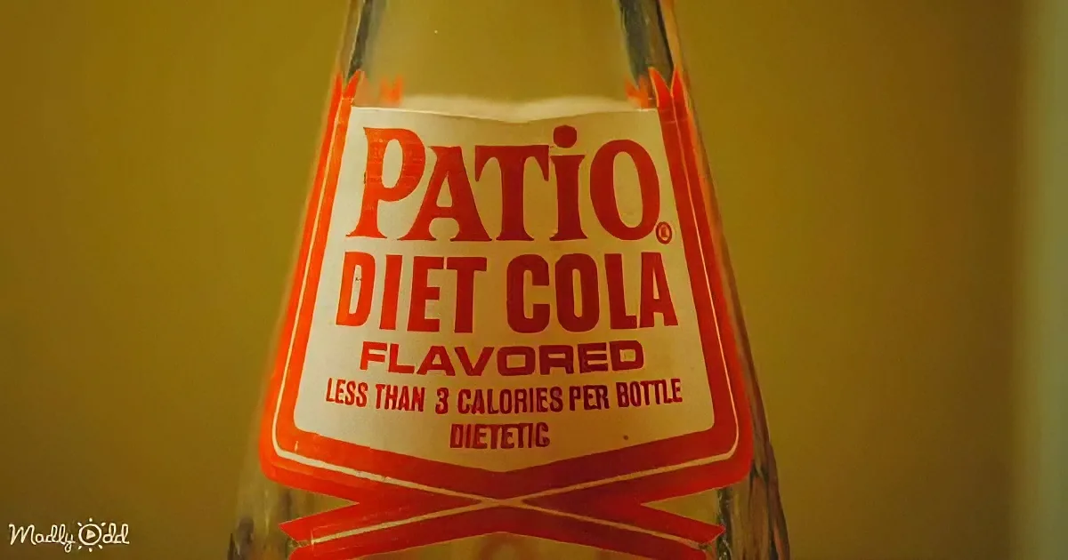 A close-up of a Patio Diet Cola bottle with a yellow background.