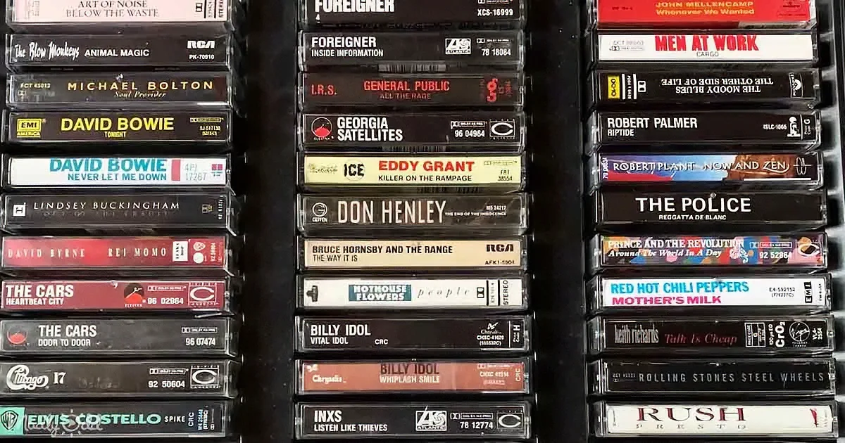 A collection of vintage cassette tapes featuring artists like Foreigner, The Police, and The Cars.