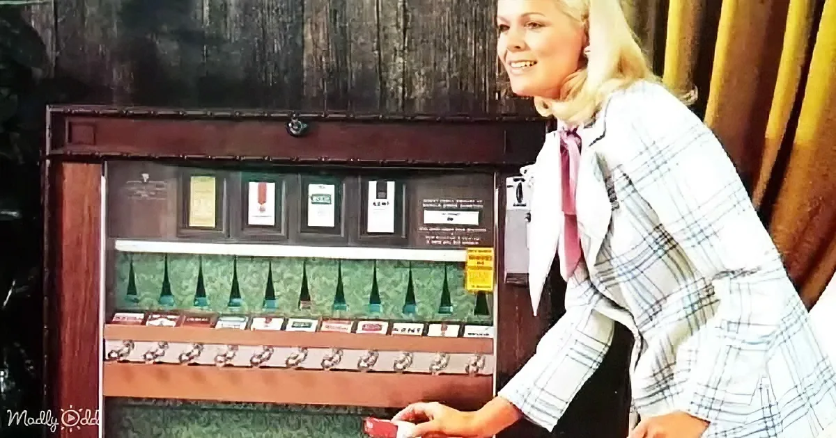 A woman in a plaid jacket smiles while interacting with a display of perfume bottles and awards.