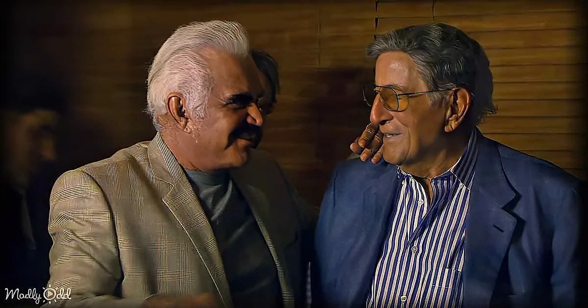 Two older men in suits are engaged in a conversation, one touching the other's face.