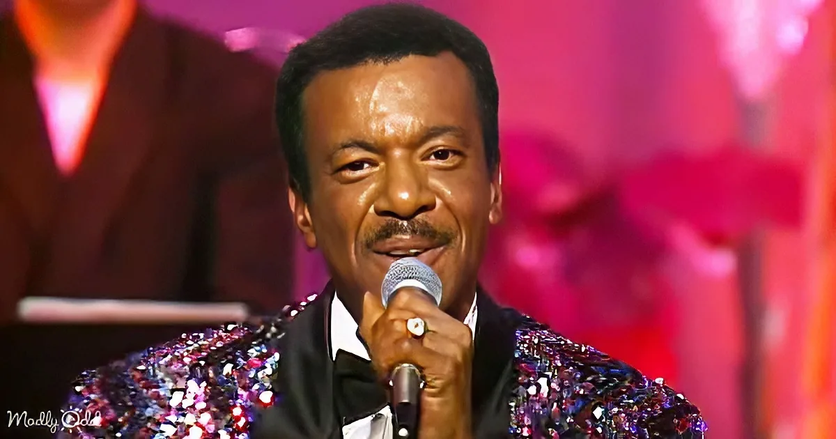 A man in a glittery sequined jacket sings into a microphone, holding a cigarette.