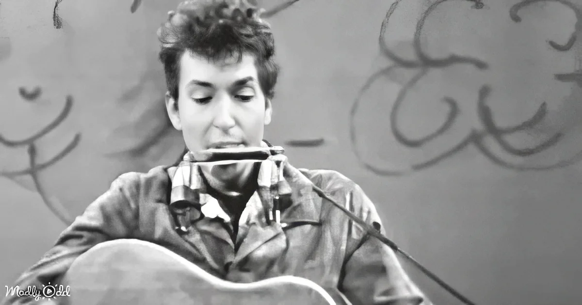 A man plays harmonica and guitar, wearing a plaid shirt, against a graffiti backdrop.