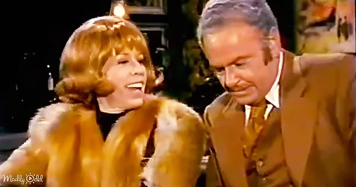 A woman in a fur coat smiles widely, while a man in a suit leans in, both appearing engaged in a conversation.