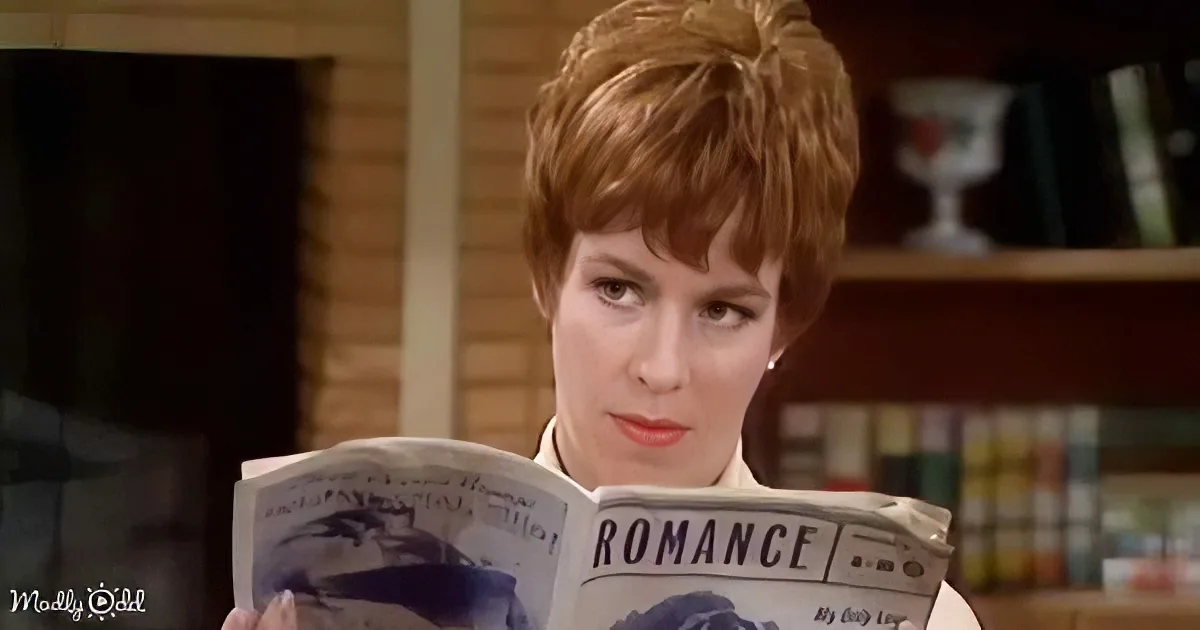 A woman with short red hair reads a romance magazine, her expression thoughtful.