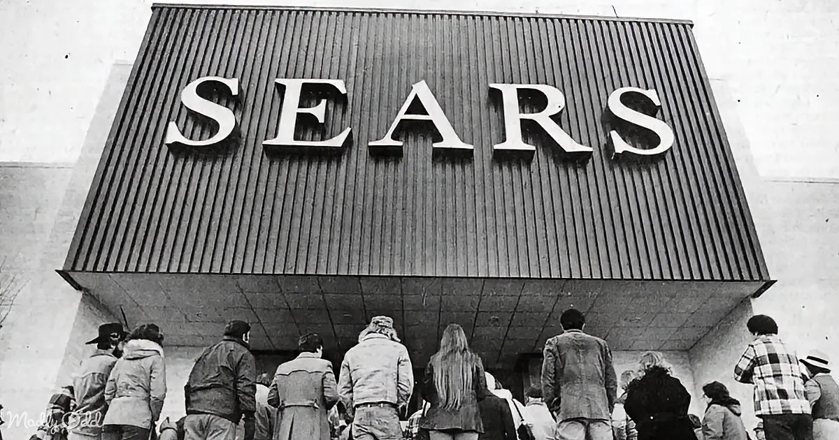 People queue outside a large Sears store with a prominent sign.