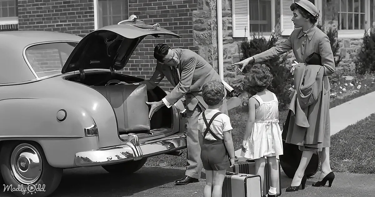 A family packs their car for a trip, with luggage and a vintage car in a suburban setting.